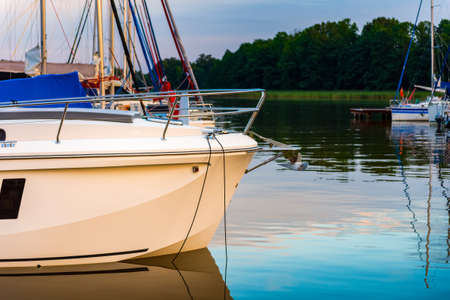 moored sailboats on a pier calm early morning. summer sailing vacations.の写真素材