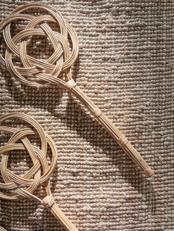 carpet beater lays on a jute carpetの写真素材