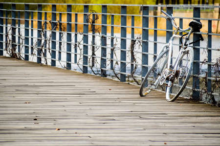Bicycle on the pier. Old white rusty bicycle park at the wooden pier.の写真素材