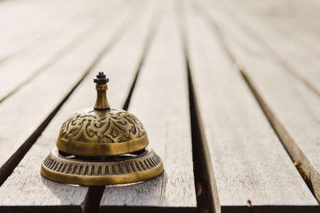 Vintage service bell on wooden surface, horizontal photoの写真素材