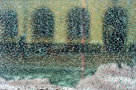 View of city through cracked glass, horizontal view