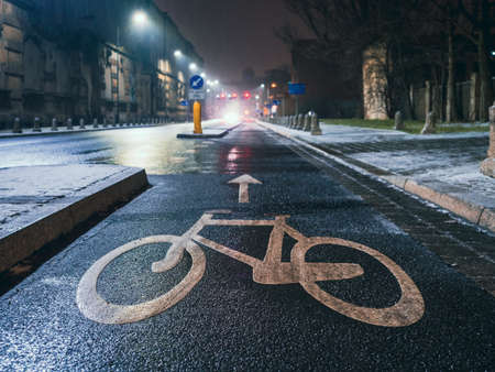bicycle sign on asphalt on a bike road in a night cityの写真素材