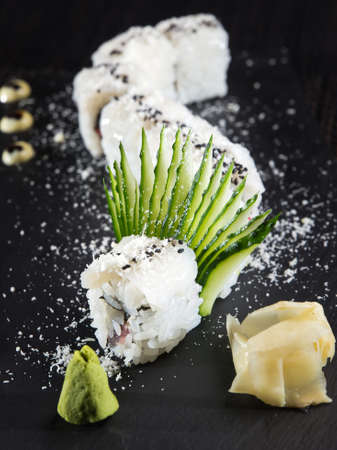 sushi roll with sesame on a black stone plate, close up photo on dark backgroundの写真素材