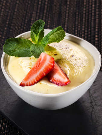 mousse dessert in bowl, whipped cream with strawberry, vertical photo on dark backgroundの写真素材