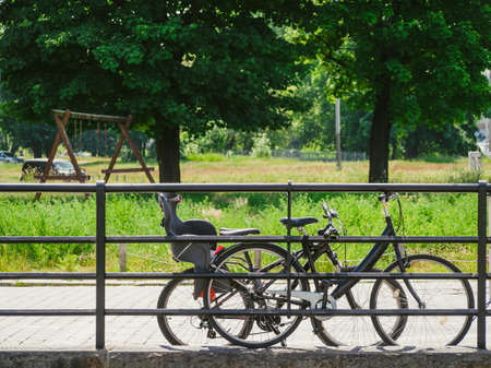 two bicycles parked near metal fence in a cityの写真素材
