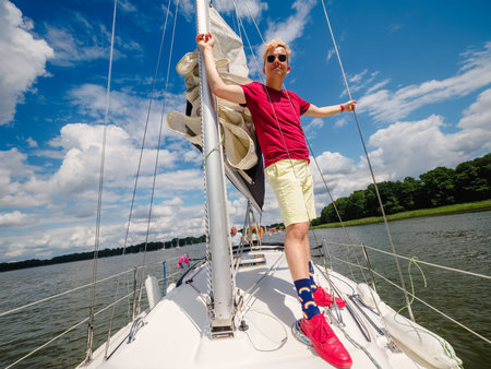 handsome young blond hair person wear casual clothes standing on a sailboat bow and looking at front...