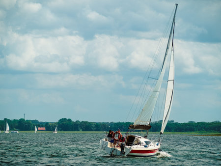 Sailboat sailing on a lake in a windy sunny summer day