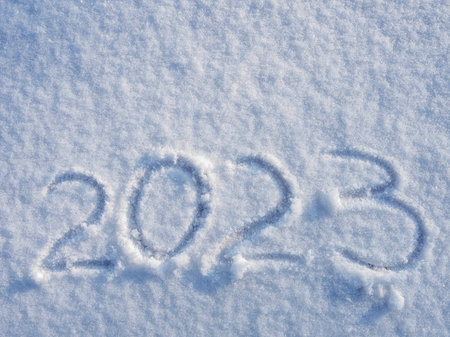 top view on 2023 hand written on the snow. 2022 new year holiday text drawn on snow. 2022 year hand written in snowの写真素材