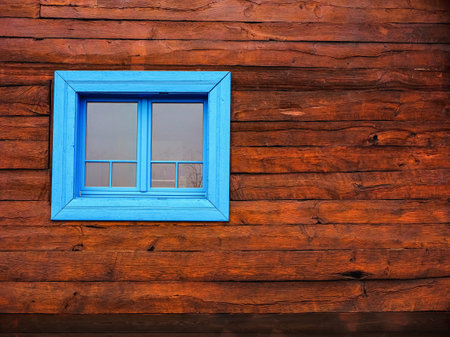 wooden farmhouse wall and a blue framed window, close up front textured viewの写真素材
