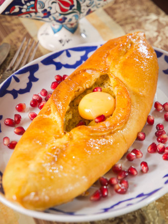 Khachapuri is a famous Georgian cheese bread, shaped like a boat and filled with cheese, butter, and an eggの写真素材