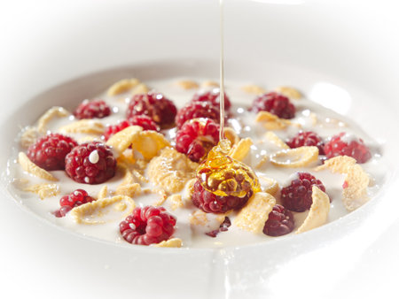 tasty breakfast, corn flakes with fresh raspberry, milk and honeyの写真素材