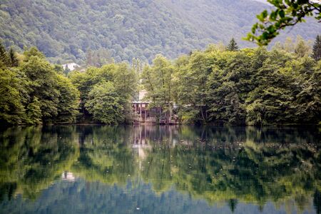 The sky is reflected in the lake among the forestの写真素材