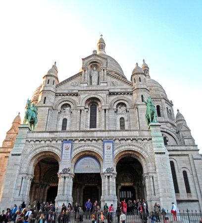 People sitting near The Basilica of the Sacred Heart of Paris, commonly known as Sacre-Coeur Basilica, Franceのeditorial素材