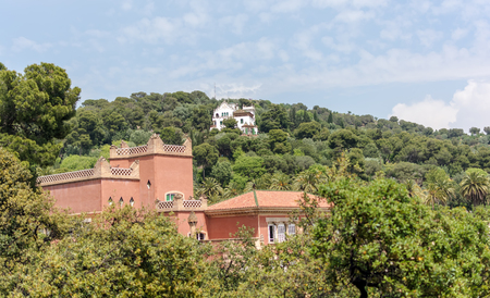 Red eighteenth century building of Baldiri Reixac school (former farmhouse residence of Count Guell), named Casa Larrard, and white Casa Trias in Park Guell, Barcelona, Spain.のeditorial素材
