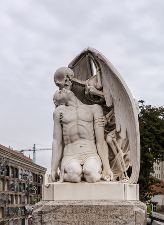 The Kiss of Death statue in Poblenou Cemetery in Barcelona. This marble sculpture depicts death, as a winged skeleton, kissing a handsome young man. The sculpture is at once romantic and horrifying.のeditorial素材