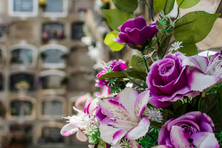 Bouquet of purple artificial flowers against the burial niches at Poblenou Cemetery in Barcelona, Spain. Spanish cemeteries have a system where a coffin is inserted in niche, rather than ground.の写真素材