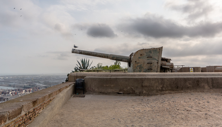 Seagull sitting on the muzzle of the gun in Montjuic Castle against cloudy sky. Montjuic Castle is an old military fortress, built on top of Montjuic hill. Now it serves as a municipal facility.のeditorial素材