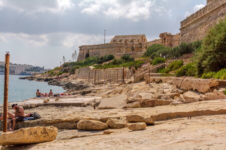 Gzira, Malta - September 4, 2019: People relaxing and taking a sun at Fort Manoel beach.のeditorial素材