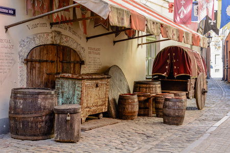 Riga, Latvia - April 5, 2020: Picturesque decoration with  middle-aged wagon, wooden barrels and...