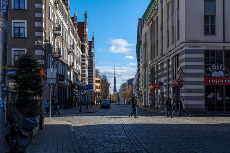 Riga, Latvia - April 5, 2020: A few people walking at the empty Old Town's street in Coronavirus...