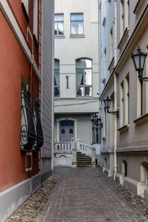 Narrow street in Riga Old Town with stone porch and cobblestone road.の写真素材