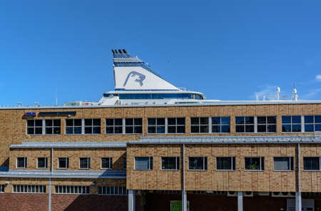 Helsinki, Finland - August 23, 2020: Olympia Terminal building of Port of Helsinki with Silja Line ferry's funnel seen above the roof. Seal's head logo on the ferry funnel.のeditorial素材