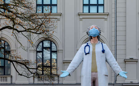Riga, Latvia - November 6, 2020: Sculpture 'Medics to the World' honouring the health care workers battling Covid-19. It shows a woman in lab coat, mask and gloves stretching to the sky.のeditorial素材