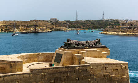 Valletta, Malta - June 28, 2021: Bronze figure of recumbent corpse, wrapped in shroud, reaching out towards the Grand Harbour, symbolising 7000 people who lost their lives during the Second World War.のeditorial素材