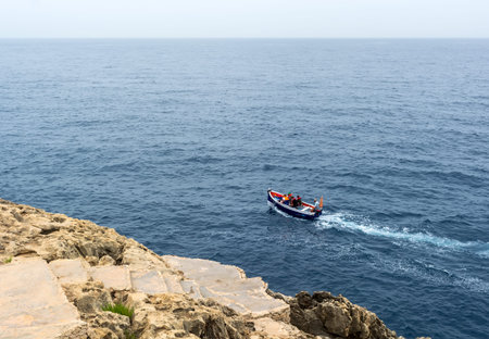 Zurrieq, Malta - June 30, 2021: Aerial top view of luzzu - traditional wooden colorful fishing boat...