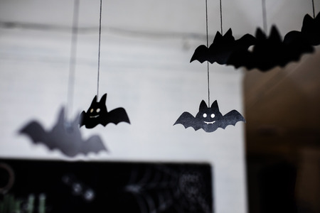 Black paper bats under the ceiling. Defocused background.の写真素材