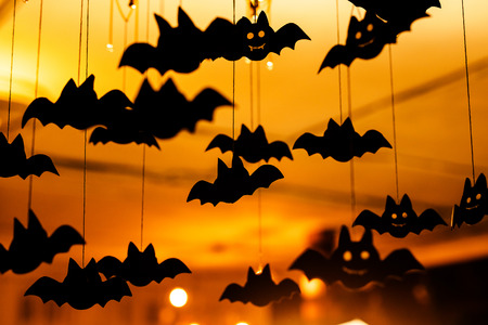 Black paper bats under the ceiling. Defocused background.の写真素材