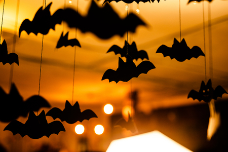 Black paper bats under the ceiling. Defocused background.の写真素材