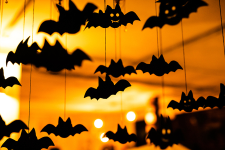 Black paper bats under the ceiling. Defocused background.の写真素材