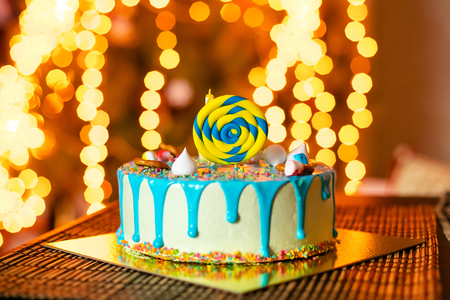 Birthday white cake with sweets and candle for little baby boy and decorations for cake smashの写真素材