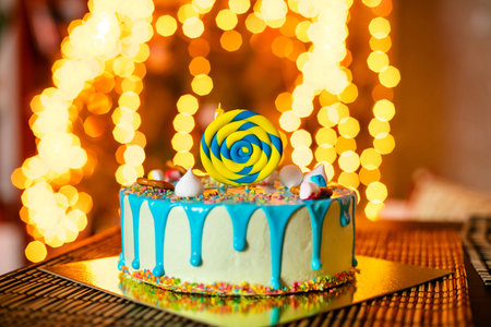 Birthday white cake with sweets and candle for little baby boy and decorations for cake smash
