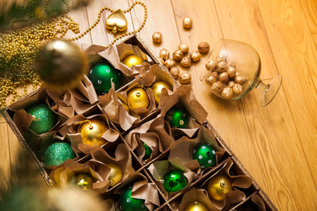 Wooden box with golden and green balls and toys for the decor. Christmas and New Year.の写真素材