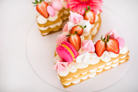 Tasty beautiful pink cake with strawberries, marshmallows, macaroons and huge flower gor the 2 years birthday party .の写真素材