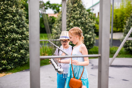 Blonde girl and boy in the hat and big glasses in playground in the park with science experiments.の写真素材