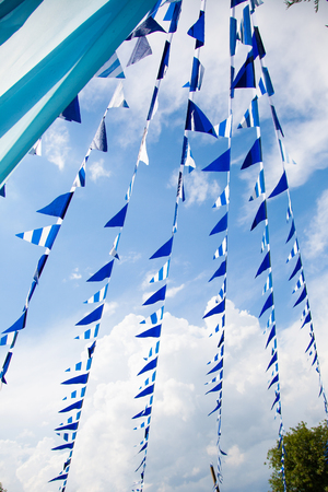 estival flag line with blue sky in background. flag background hanging on blue sky for fun fiesta party event, summer holiday farm feast celebration, carnival.の写真素材
