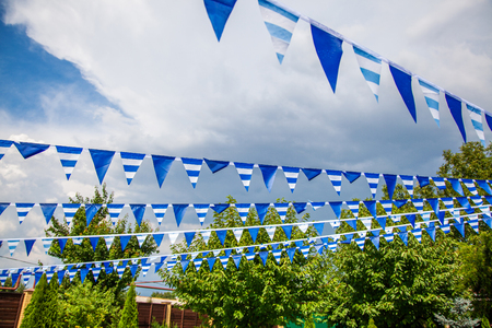 estival flag line with blue sky in background. flag background hanging on blue sky for fun fiesta party event, summer holiday farm feast celebration, carnival.の写真素材
