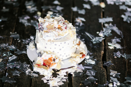 Smashed first birthday white cake with stars and one candle for little baby boy and decorations. Black background.の写真素材