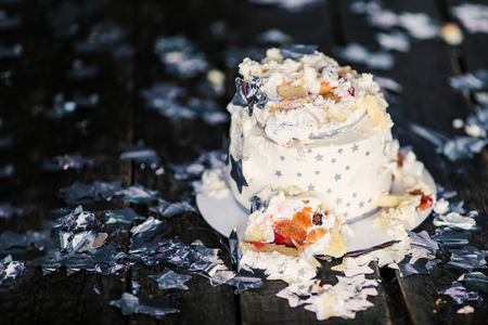 Smashed first birthday white cake with stars and one candle for little baby boy and decorations. Black background.の写真素材