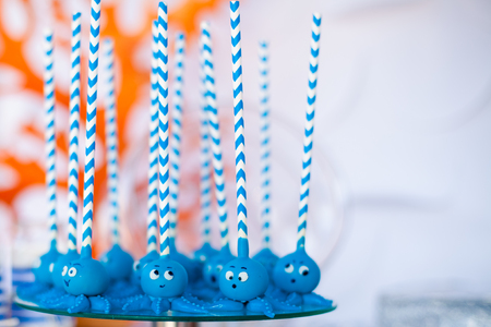 Blue cake pops funny octopuses shared on the glass round plate. Summer candy bar on the party, birthday.の写真素材