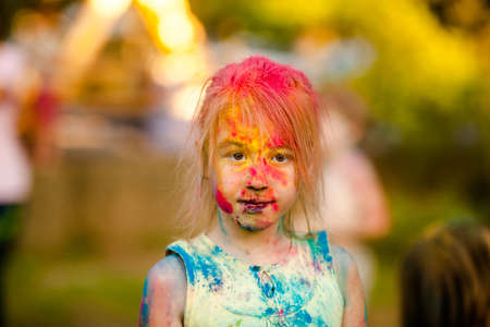 Portrait of a cute girl painted in the colors of Holi festival.の写真素材