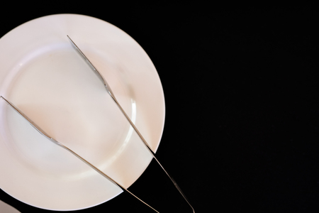 The tableware, stainless spoon and fork, in a wicker basket on the wooden table.の写真素材