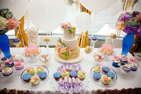 luxury wedding catering, table with modern desserts, cupcakes, sweets with fruits. delicious candy bar at expensive wedding reception. space for text. shower. holiday celebration.の写真素材