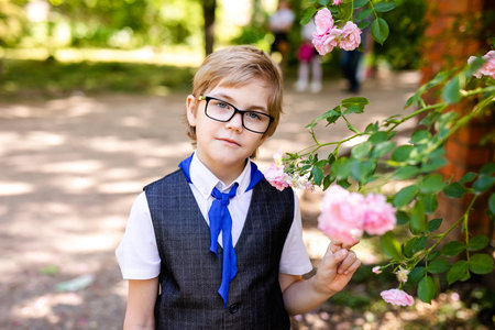 Happy little schoolboy with glasses and red tie. Back to school outdoorの写真素材