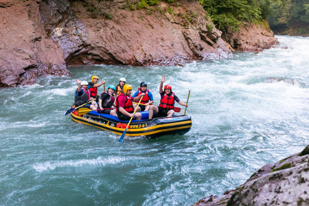 A group of men and women are rafting on the river, extreme and fun sport. RUSSIA, GUZIRIPL. August,...