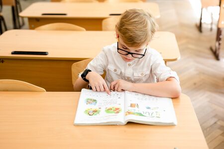 Education, high school, college. Portrait of a funny shouting student boy standing by a school blackboard.の写真素材