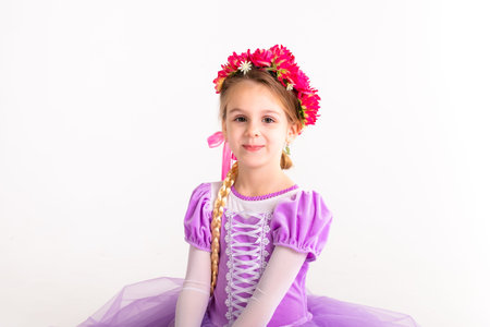 Little blonde girl wearing purple fairy princess dress on white background. Kids costume for new...